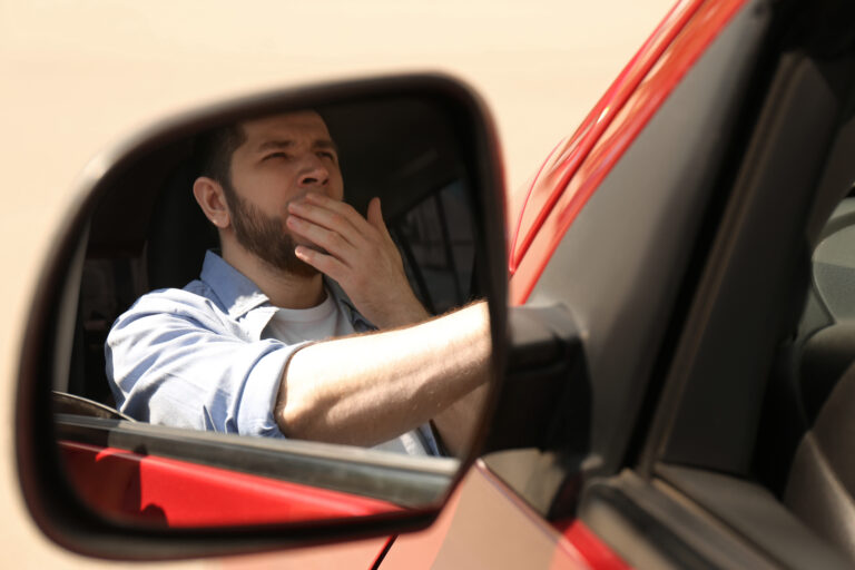 A tired driver gripping the steering wheel