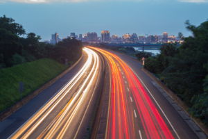 Highway traffic at dusk illustrating speeding awareness during National Traffic Awareness Month